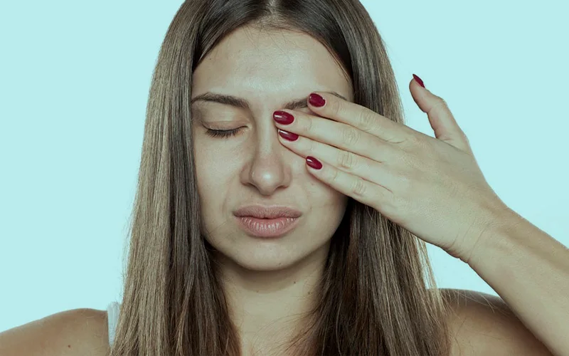 Девушка закрывает ладонью один глаз